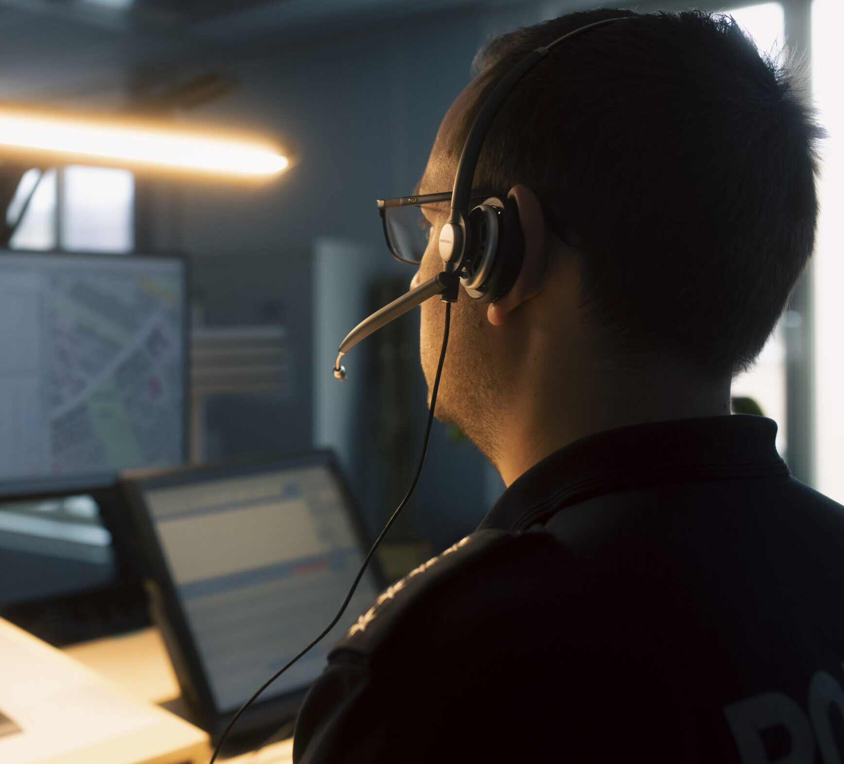 Ein Polizeibeamter mit Headset nimmt in der Einsatzleitzentrale Notrufe an.